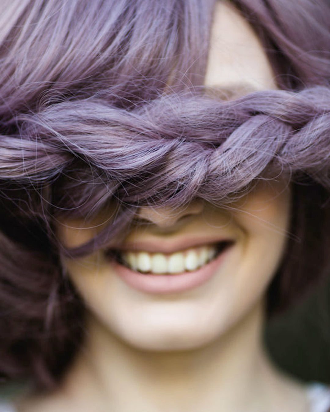 Femme en train de tresser sa natte, geste symbolique du tressage d’un bracelet Tweed Co. portant un prénom, expression de l’appropriation personnelle et émotionnelle.