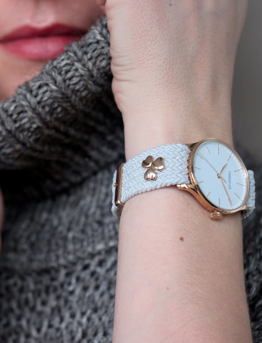 Montre Tweed Co. Kate Or Rose 36 mm portée avec trois charms Cœur, sur bracelet tressé, symbole d’élégance et de personnalisation romantique