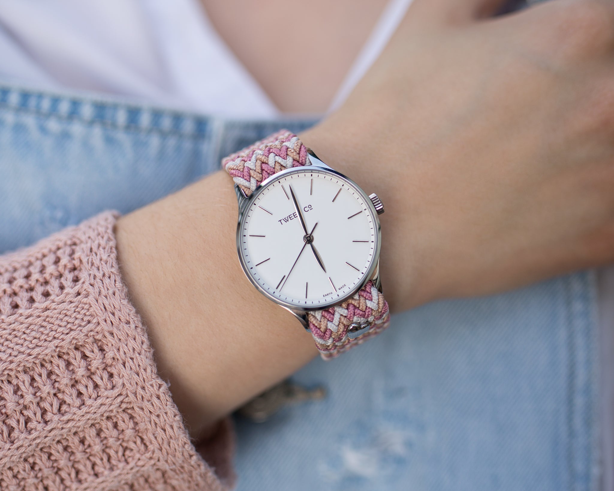 Montre Tweed Co. rose avec bracelet tressé rose, portée avec un pull rose assorti